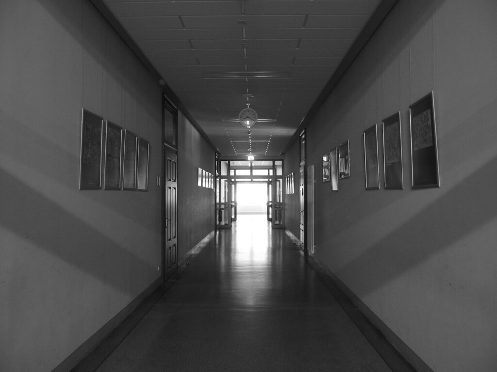 Long empty school corridor with doors and windows, relevant to school fire safety checks