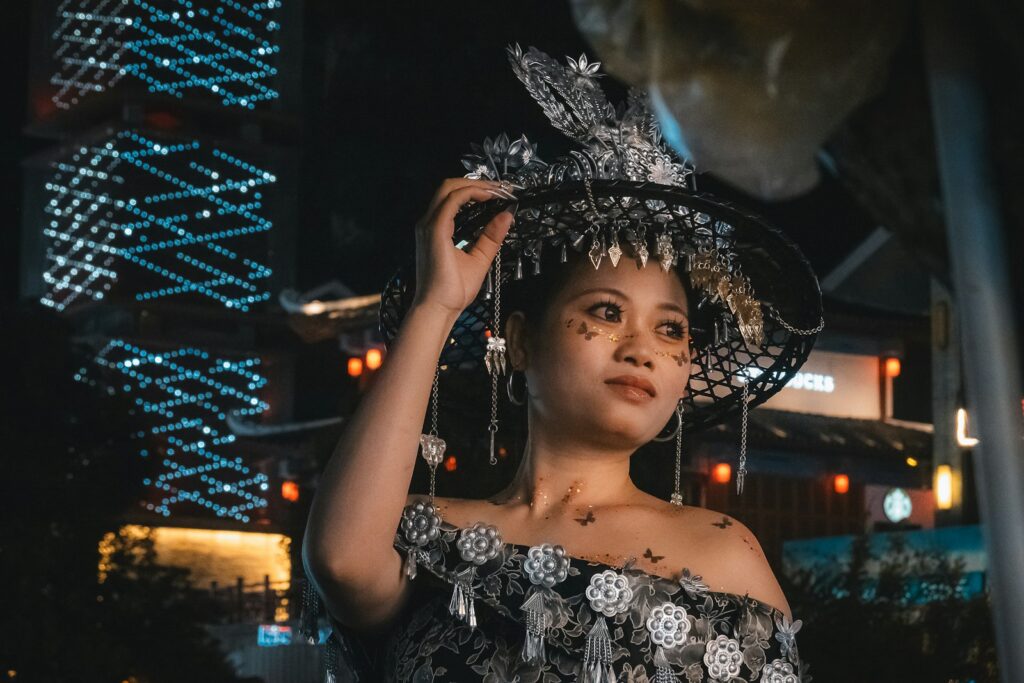 Woman wearing an ornate hat and dress at night, an elegant look for evening events